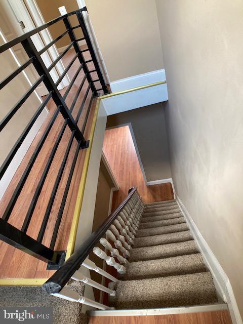 stairs featuring wood finished floors and baseboards