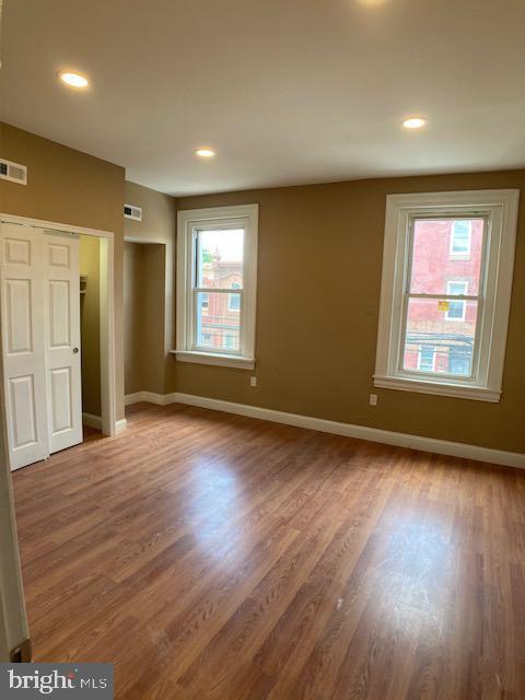 unfurnished bedroom with recessed lighting, wood finished floors, visible vents, and baseboards