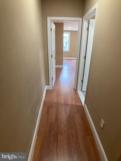 hallway with baseboards and wood finished floors