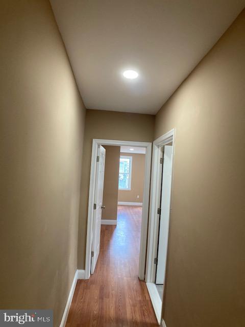 hall with light wood finished floors and baseboards