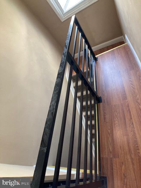 stairway with wood finished floors and baseboards