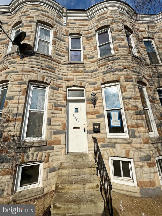 view of front of property with entry steps and stone siding