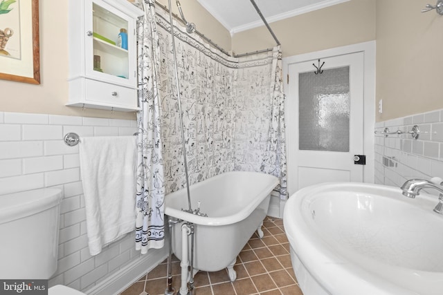 bathroom with tile patterned flooring, toilet, a freestanding tub, tile walls, and ornamental molding