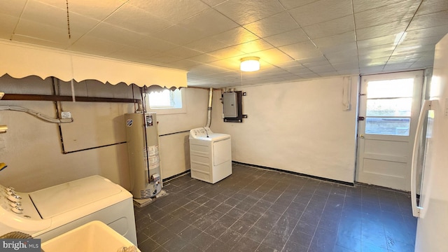 below grade area featuring electric panel, washing machine and dryer, water heater, and dark floors