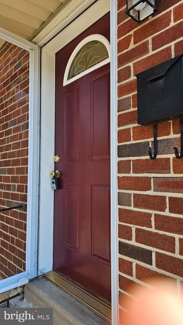 view of exterior entry with brick siding