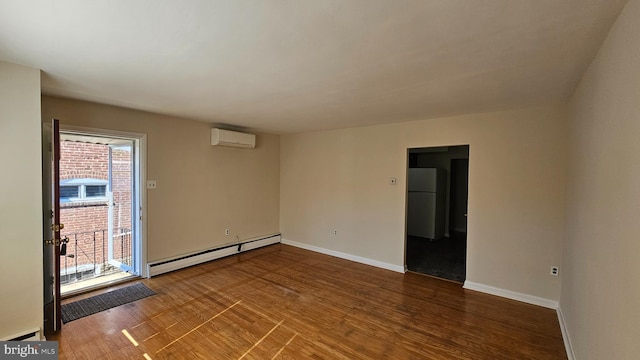 empty room featuring dark wood-type flooring, baseboard heating, a wall mounted AC, and baseboards