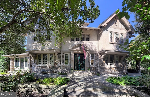 view of front of home featuring entry steps, stone siding, and stucco siding