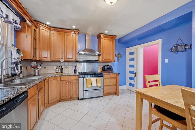 kitchen featuring a sink, appliances with stainless steel finishes, wall chimney exhaust hood, light tile patterned floors, and decorative backsplash