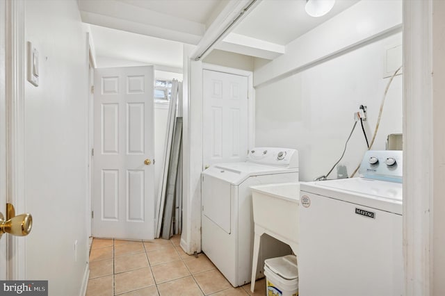 laundry room with washer and clothes dryer, light tile patterned floors, and laundry area