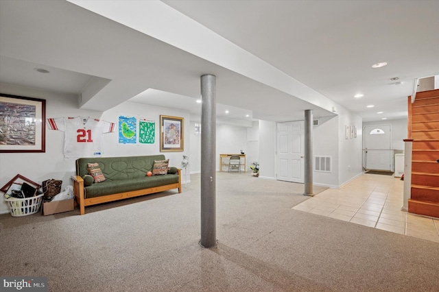 finished basement with visible vents, recessed lighting, stairs, tile patterned flooring, and carpet flooring