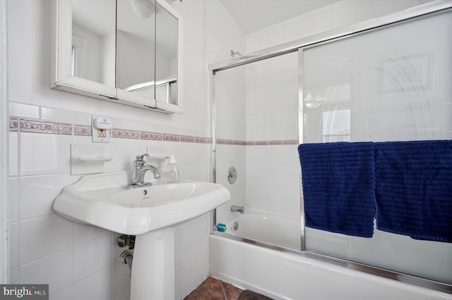 bathroom featuring enclosed tub / shower combo and tile walls