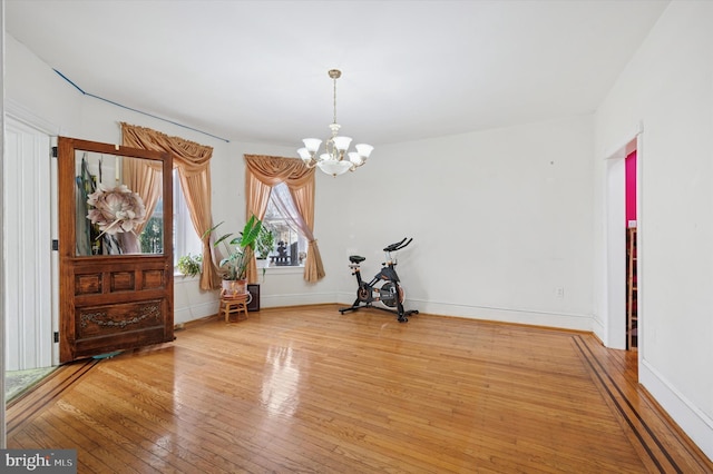 interior space with a chandelier, baseboards, and wood-type flooring