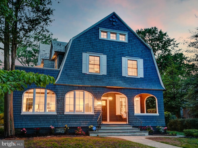 view of front of home with a porch and a gambrel roof