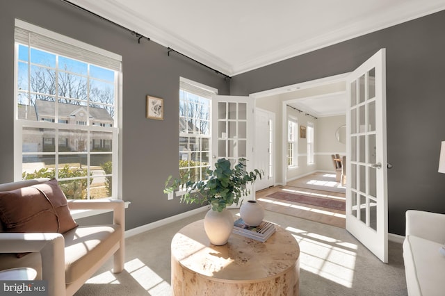 sitting room featuring carpet floors, crown molding, a wealth of natural light, and french doors