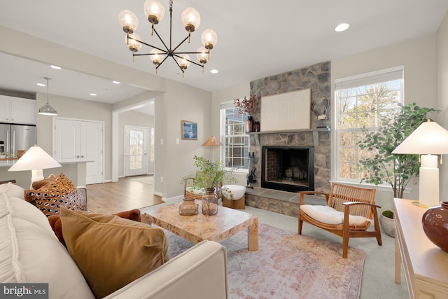 living room with baseboards, a fireplace, a notable chandelier, and recessed lighting