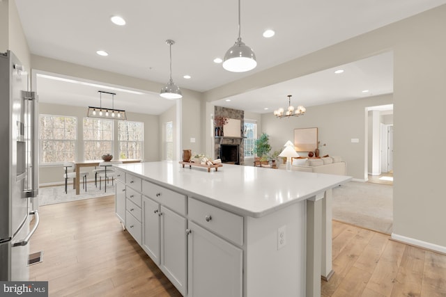 kitchen with a healthy amount of sunlight, light wood finished floors, open floor plan, and light countertops