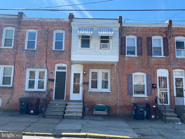 view of property featuring entry steps and brick siding