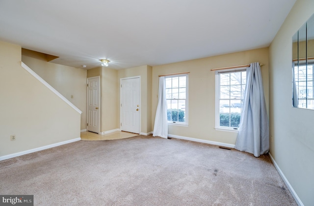 empty room with baseboards, visible vents, and carpet flooring