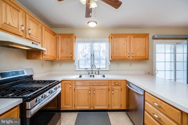 kitchen with appliances with stainless steel finishes, plenty of natural light, a sink, and under cabinet range hood