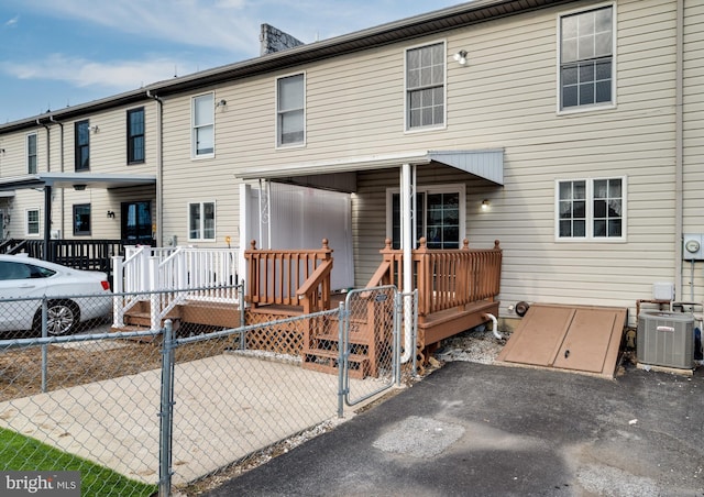 view of front of home featuring central air condition unit, a wooden deck, and fence