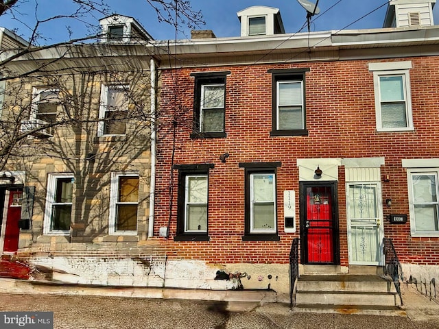 multi unit property featuring entry steps and brick siding