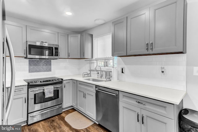 kitchen featuring a sink, stainless steel appliances, gray cabinets, and light countertops