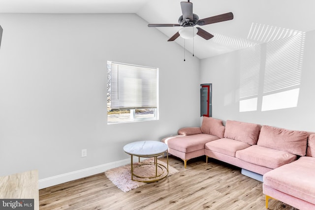 living area with vaulted ceiling, light wood-style flooring, baseboards, and ceiling fan