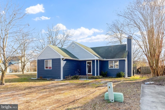 view of front of property with a chimney and fence