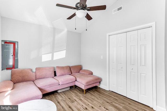 living room featuring visible vents, baseboards, vaulted ceiling, a ceiling fan, and light wood finished floors