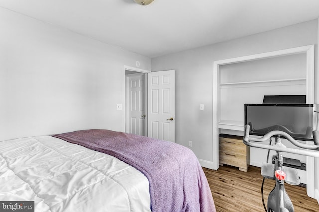 bedroom with wood finished floors and baseboards