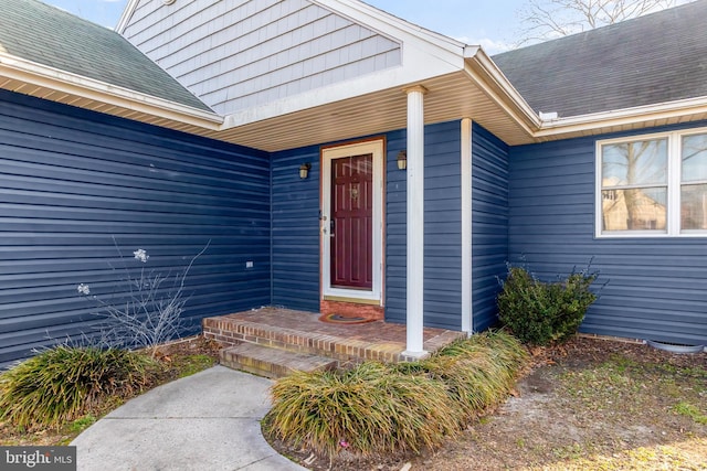 doorway to property with roof with shingles