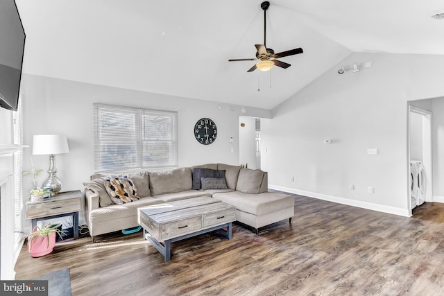 living room featuring lofted ceiling, a ceiling fan, wood finished floors, washer / dryer, and baseboards