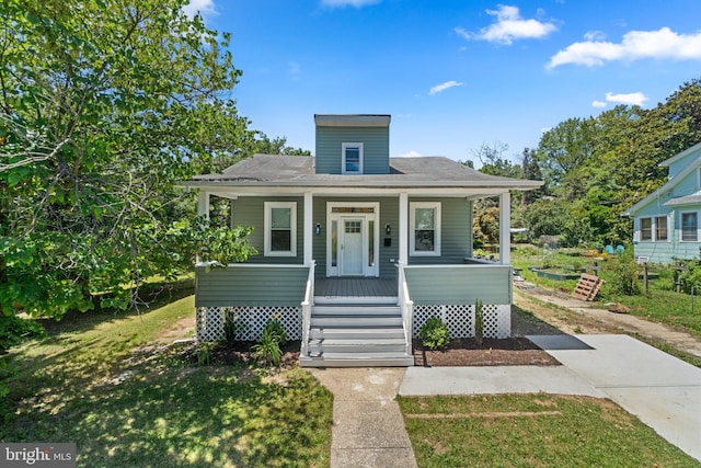 bungalow-style house featuring covered porch and a front lawn