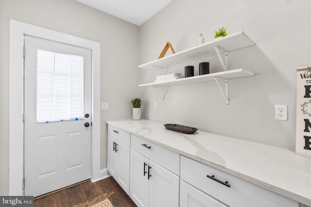 clothes washing area with dark wood finished floors