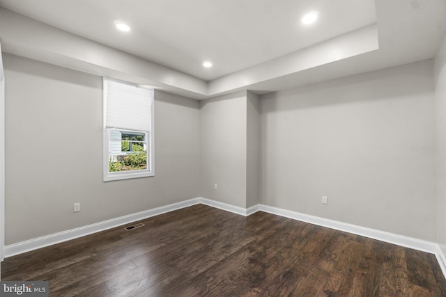 below grade area with dark wood-style flooring, recessed lighting, visible vents, and baseboards