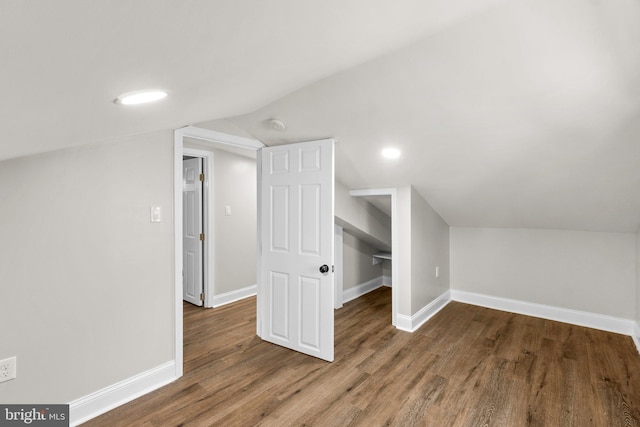 bonus room featuring dark wood-style floors, vaulted ceiling, and baseboards