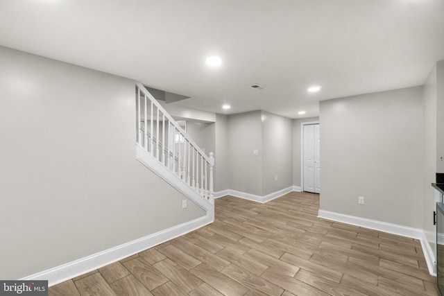 basement featuring recessed lighting, visible vents, baseboards, stairs, and light wood-style floors