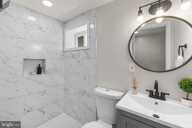 full bath featuring tiled shower, vanity, and toilet