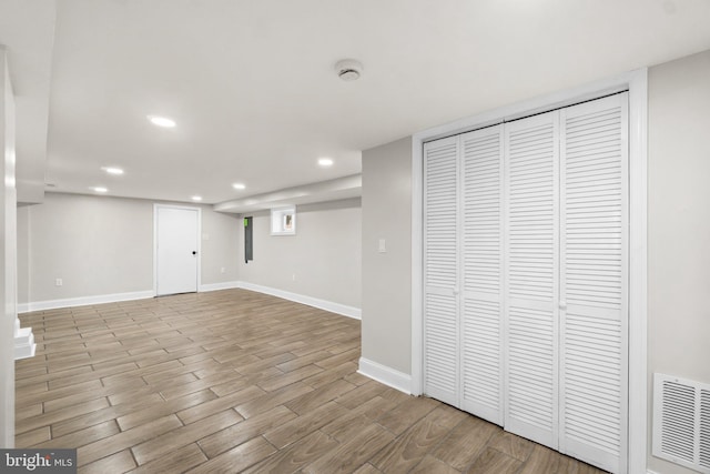 below grade area with light wood-style floors, recessed lighting, visible vents, and baseboards