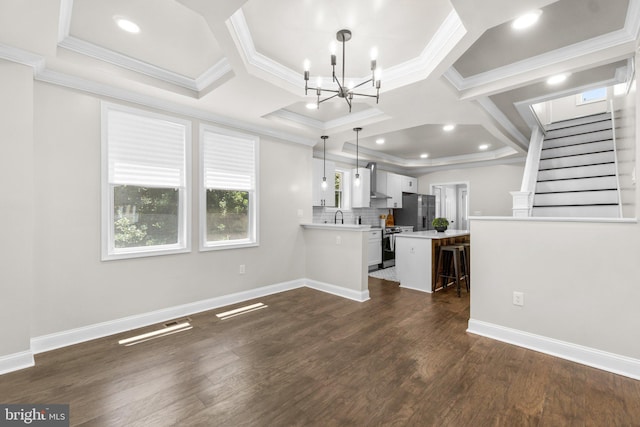 unfurnished living room with dark wood-style floors, baseboards, a notable chandelier, and crown molding