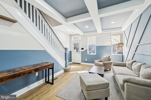 living area featuring baseboards, stairs, beam ceiling, wood finished floors, and coffered ceiling