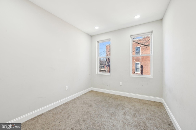 empty room with carpet flooring, recessed lighting, and baseboards