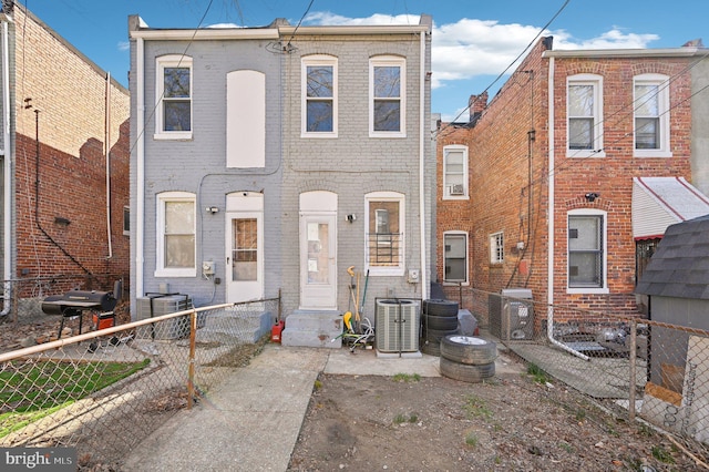 view of property featuring brick siding, central air condition unit, entry steps, and fence