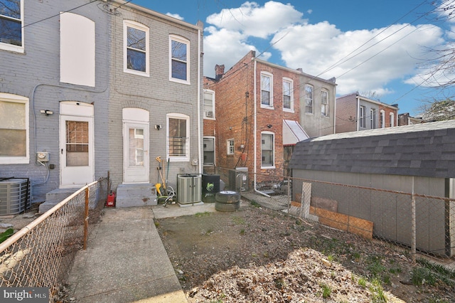 rear view of property featuring cooling unit, an outbuilding, brick siding, and entry steps