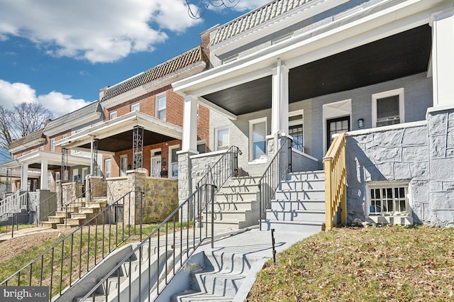 property entrance with brick siding and covered porch