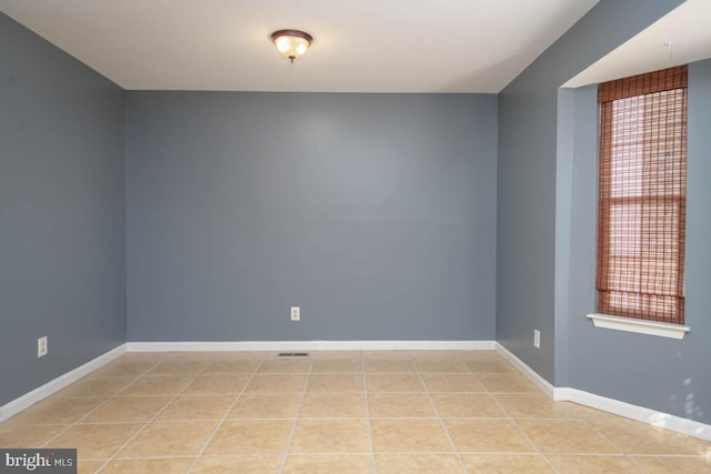 spare room with light tile patterned floors, visible vents, and baseboards