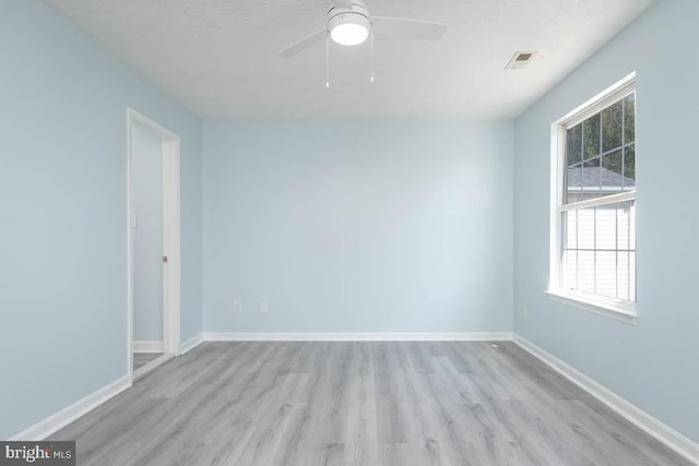 spare room featuring a ceiling fan, a textured ceiling, baseboards, and wood finished floors