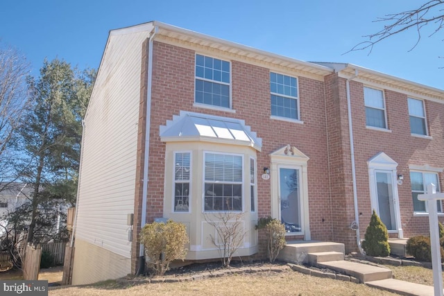 view of property featuring fence and brick siding