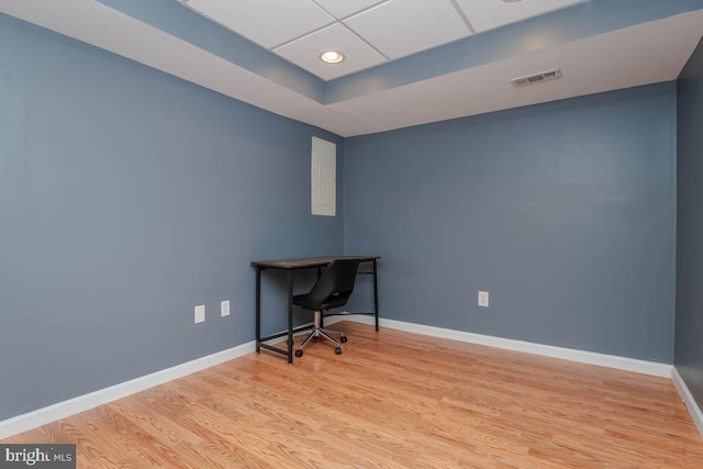 office space featuring wood finished floors, visible vents, and baseboards