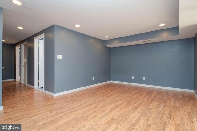 spare room featuring light wood-style flooring, baseboards, and recessed lighting